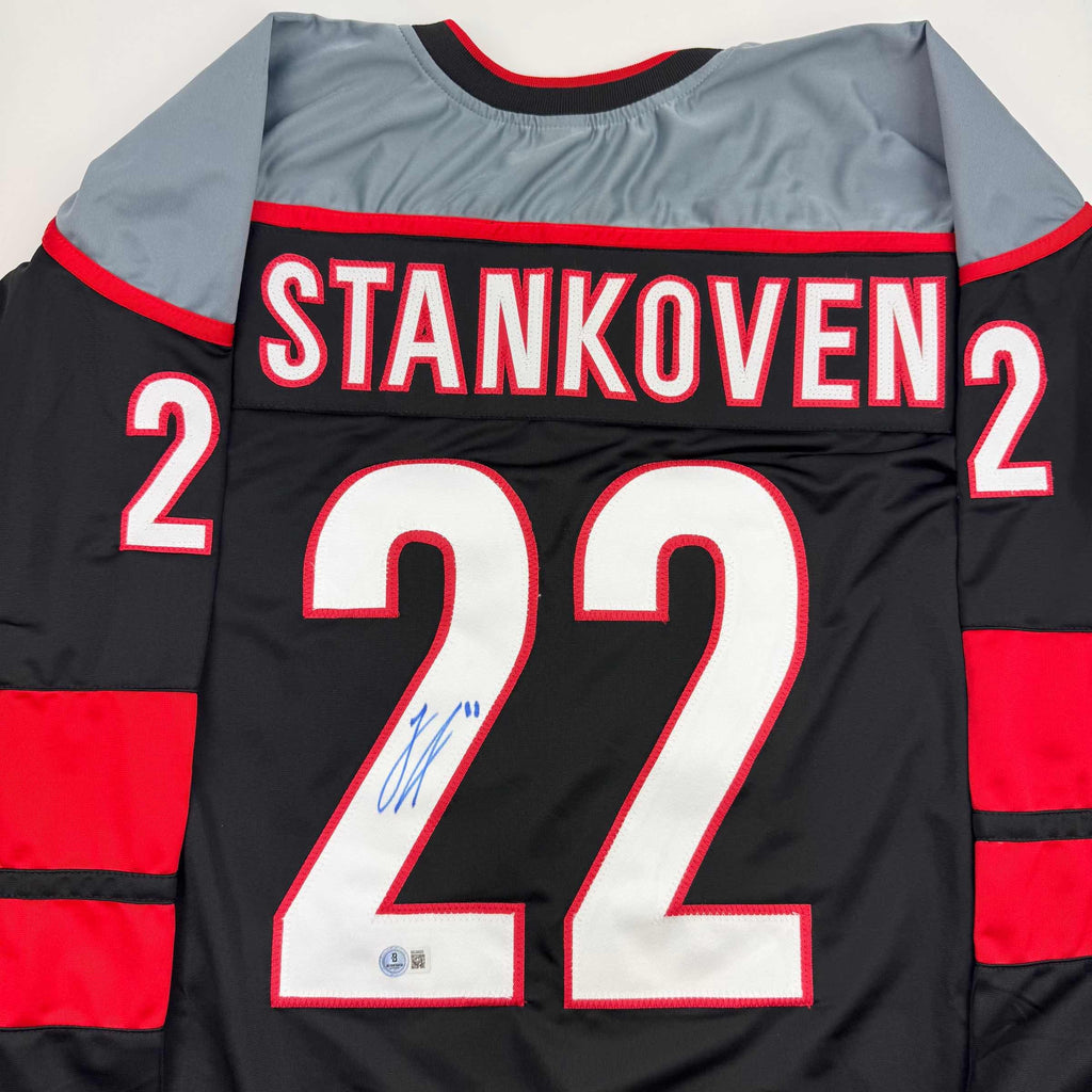 Autographed/Signed Logan Stankoven Carolina Black Hockey Jersey Beckett BAS COA